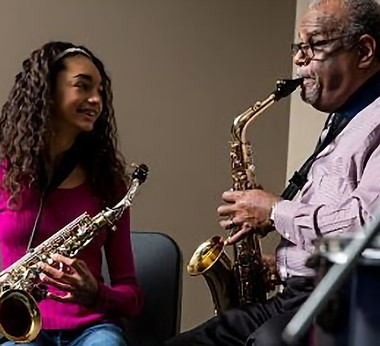 young sax student listening to older sax teacher