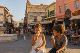 Two children enjoying ice cream in the historic streets of Chania, Crete