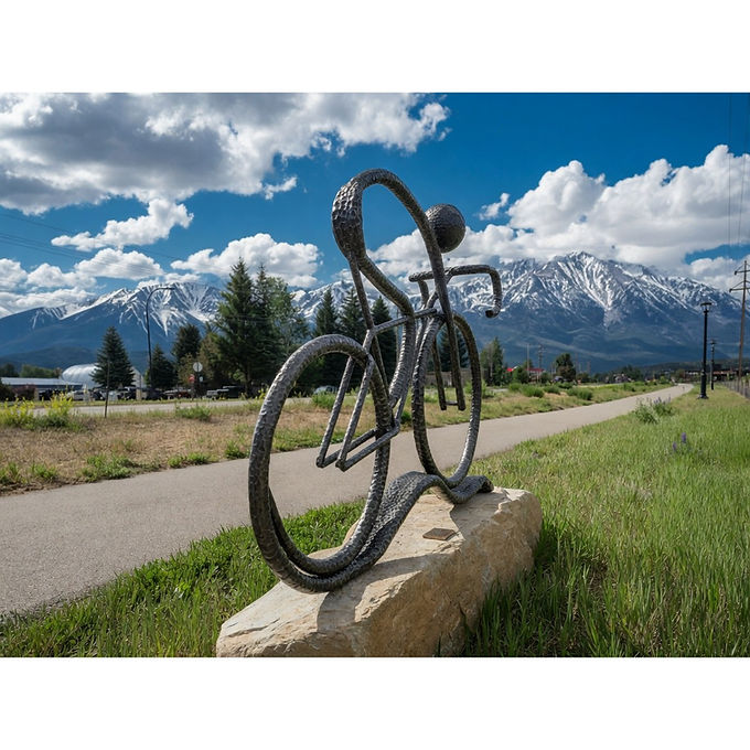 A cyclist in iron, mounted on a large rock at the start of a trail. Purchased by Foothills Park & Recreation District in 2025.