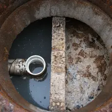 Ultra-Archaea being applied to a wastewater system to break down fats, oils, and grease (FOG), preventing blockages and improving system performance.