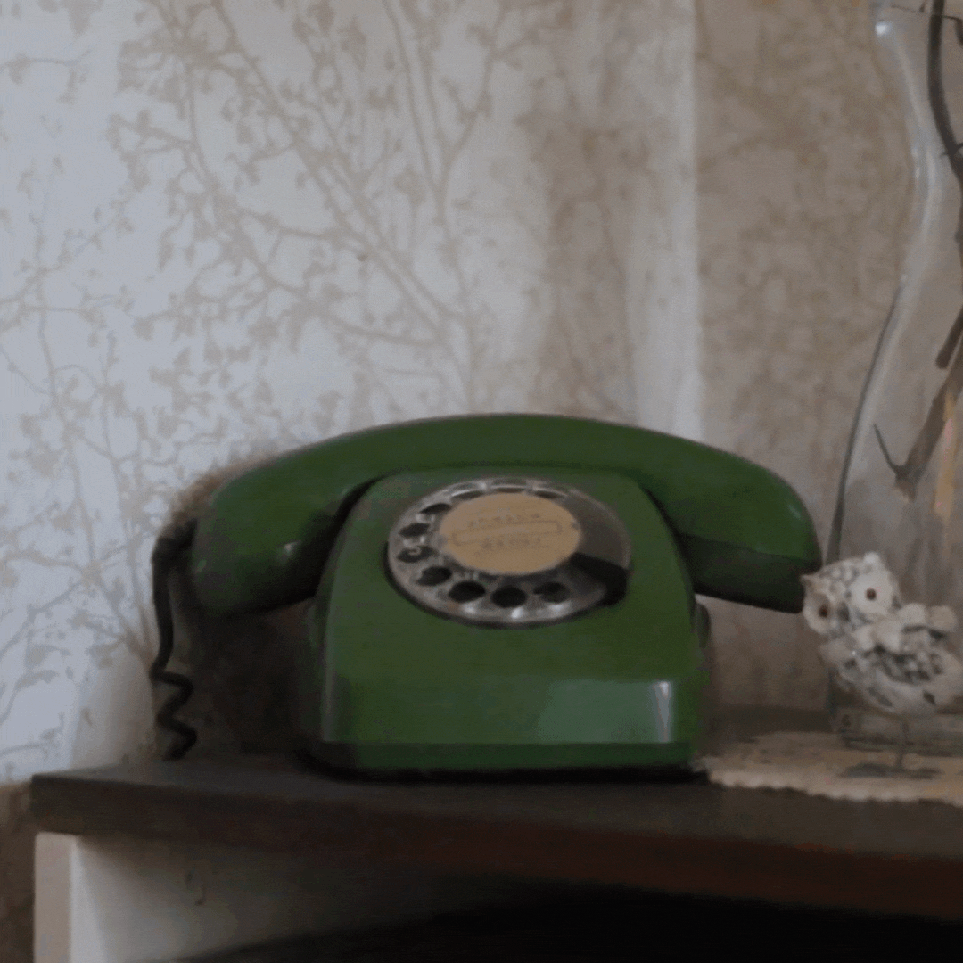 retro cord phone being lifted by hand