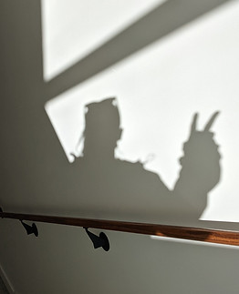 peace sign shadow reflection on a sunny wall