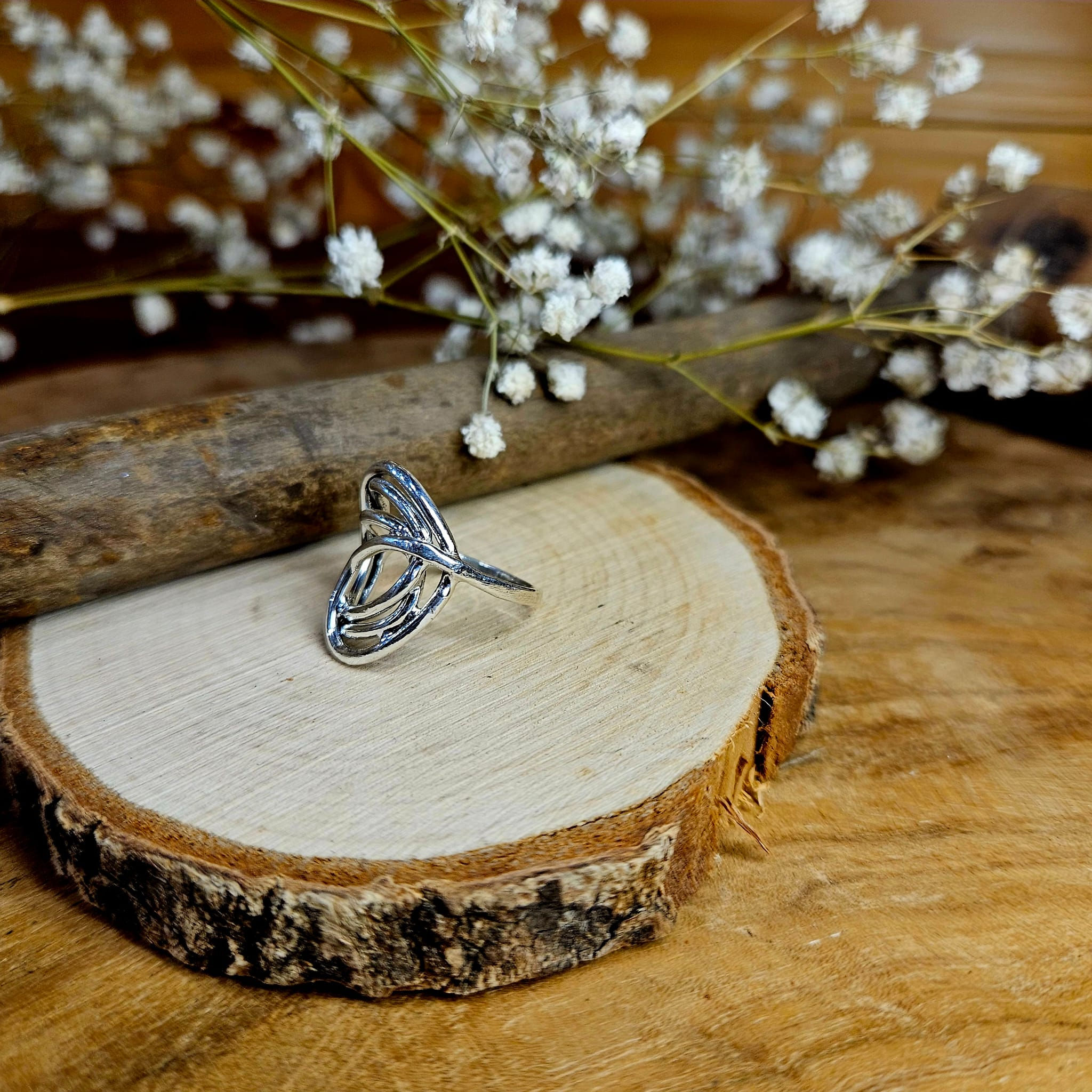 On y voit une bague en argent 925 de forme plutôt ronde. Elle est réalisée avec plusieurs cercles qui s'entremêlent légèrement sur le dessus. Les cercles sont très fins.