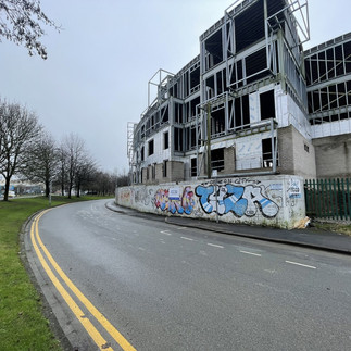 Building under construction with graffiti. UK Property investment opportunities are available with DBR Investment Group.