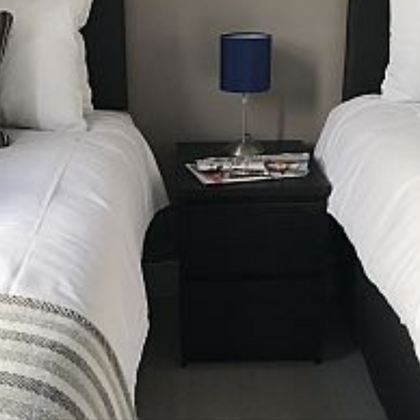 Laptop on twin beds with bedside table