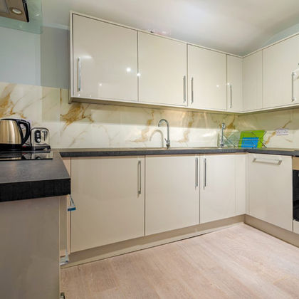 Modern kitchen with cream cabinets and marble backsplash