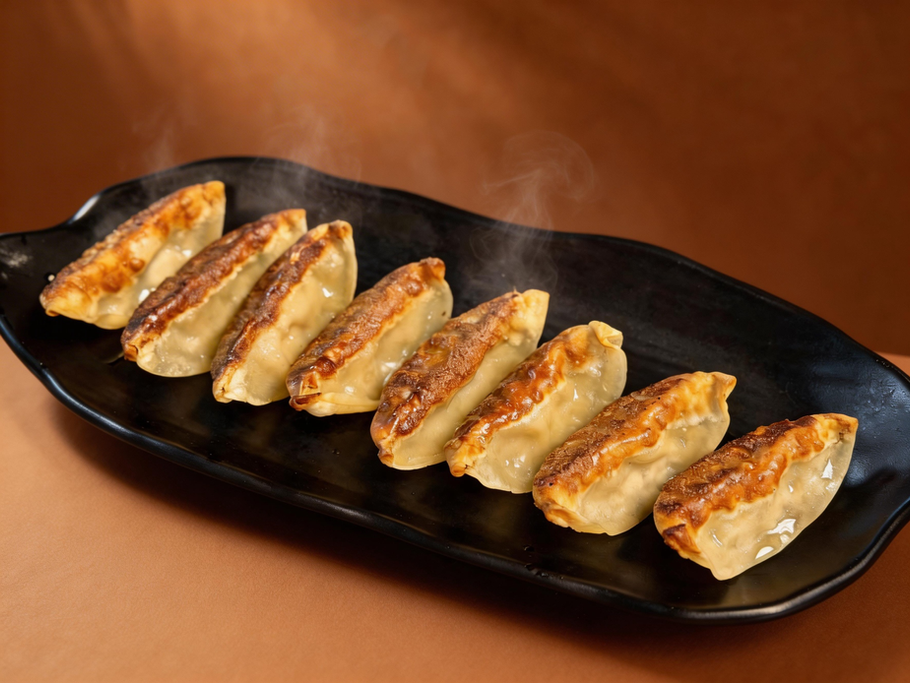 Golden brown gyoza on a black platter