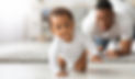 Cute Little Black Infant Baby Crawling On Floor At Home, Proud Young Father Looking At Him