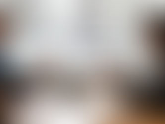 Man and woman in suits at a desk, exchanging info via phone and tablet. Office setting with city view outside. Calm, professional mood.