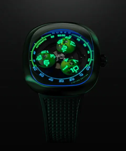 NUBEO Tri-Star Orbit Trois aiguilles en forme de dôme, gravées comme des astres miniatures, gravitent autour d’un carrousel