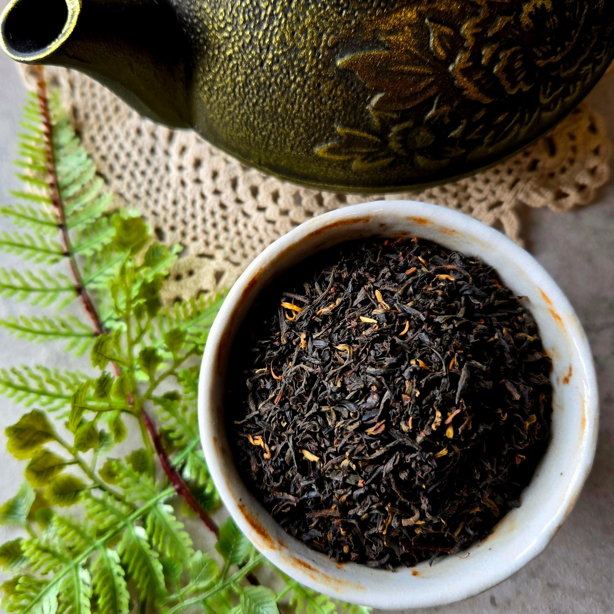 Gnat and Bee Dark Fable house black tea loose leaves in a ceramic cup