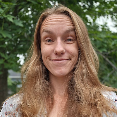 Professional portrait of a smiling mortgage loan originator outdoors, conveying a warm and approachable presence