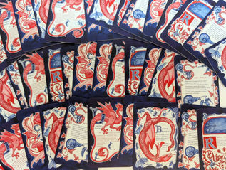 medieval bestiary vending machine. illuminated manuscipt. fantasy art. fairytale. dragons. folklore. interactive art. paper engineer. card game. game art