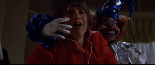 Oliver Robins as Robbie Freeling being attacked by an evil clown doll in Poltergeist 1982