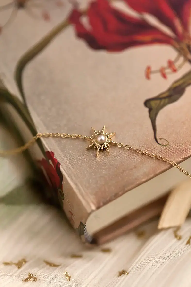 bracelet en acier inoxydable doré avec une étoile décorée d'une perle blanche au centre