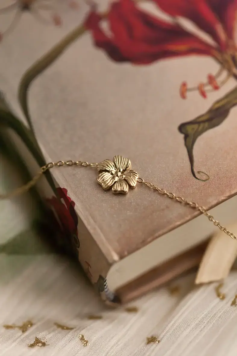 Thumbnail: bracelet en acier inoxydable doré avec une fleur détaillée