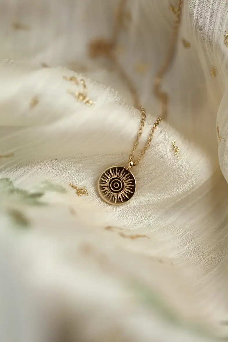 Thumbnail: collier en acier inoxydable doré avec une médaille ronde gravée d'un soleil