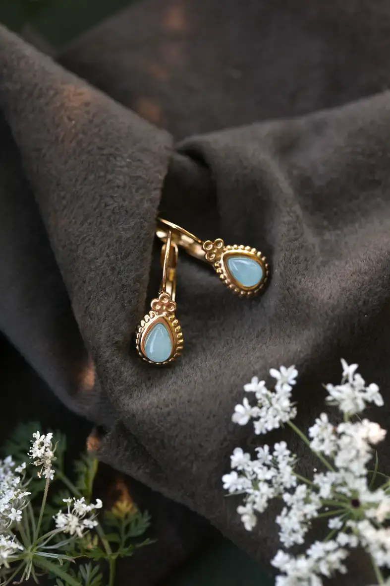boucles d'oreilles dormeuses en acier inoxydable doré avec une petite pierre bleue en forme de goutte