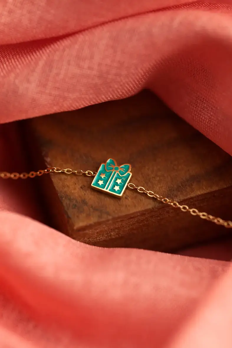 Thumbnail: bracelet ajustable pour enfant en acier inoxydable doré avec un paquet cadeau bleu turquoise