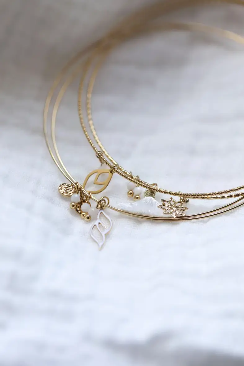 lot de quatre bracelets joncs fins en acier inoxydable avec plusieurs breloques et pampilles blanches