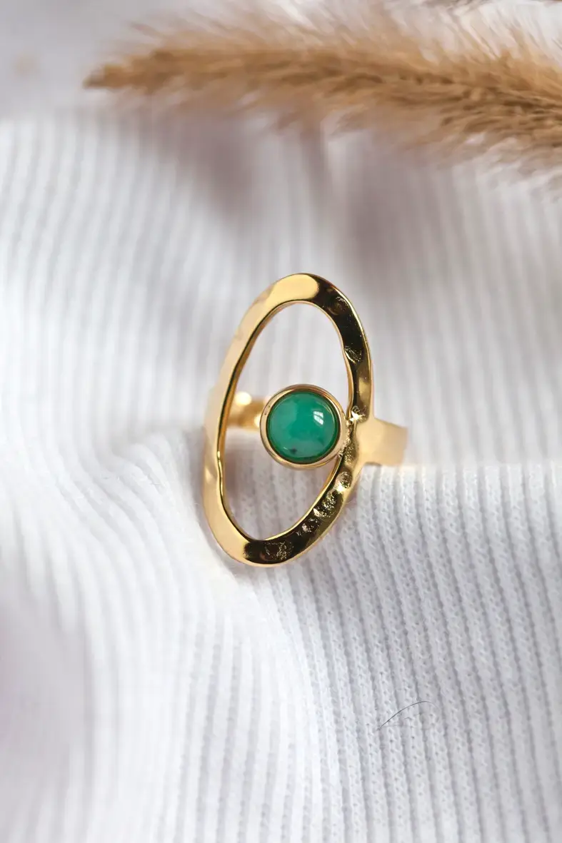 Thumbnail: bague haute ajustable de forme ovale ajourée et martelée et décorée d'une petite pierre ronde turquoise sur la droite