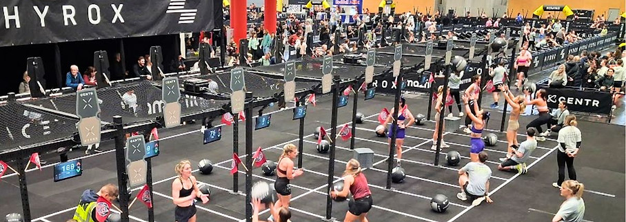 Athlete competing in the wall ball station during the HYROX Vienna fitness competition.