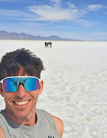 Runner selfie at Bonneville Salt Flats in Utah with mountains in the background.