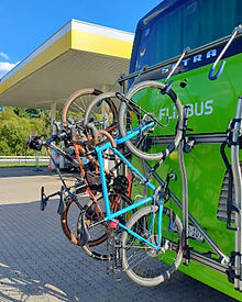 Three bicycles secured on rear rack of FlixBus prepared for intercity travel