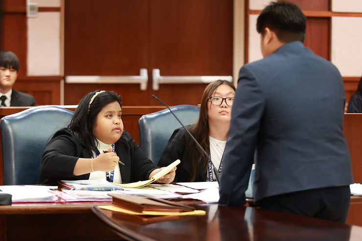 Tinian High School competitor Ainsley P. Ancheta discusses strategy with her fellow attorneys during Preliminary Round 2.