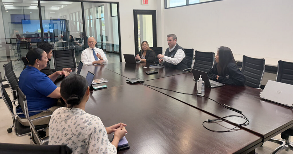 The team meets with Senior Account Executive Jason Cribbs (sixth from left) at the Guma’ Hustisia.