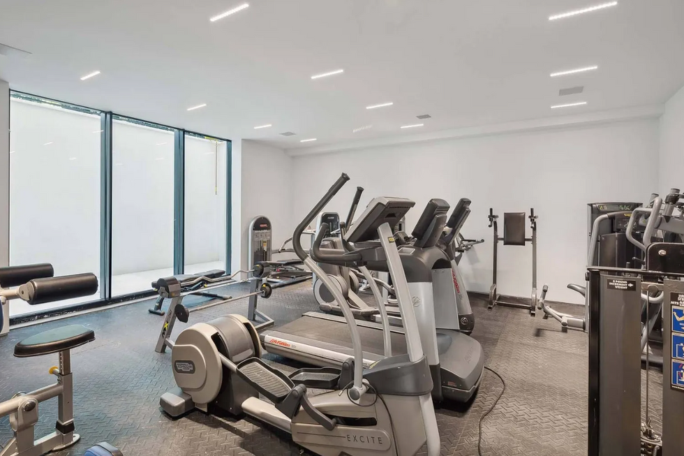 Exclusive private fitness center equipped with state-of-the-art gym equipment and natural light in a luxury Hamptons property