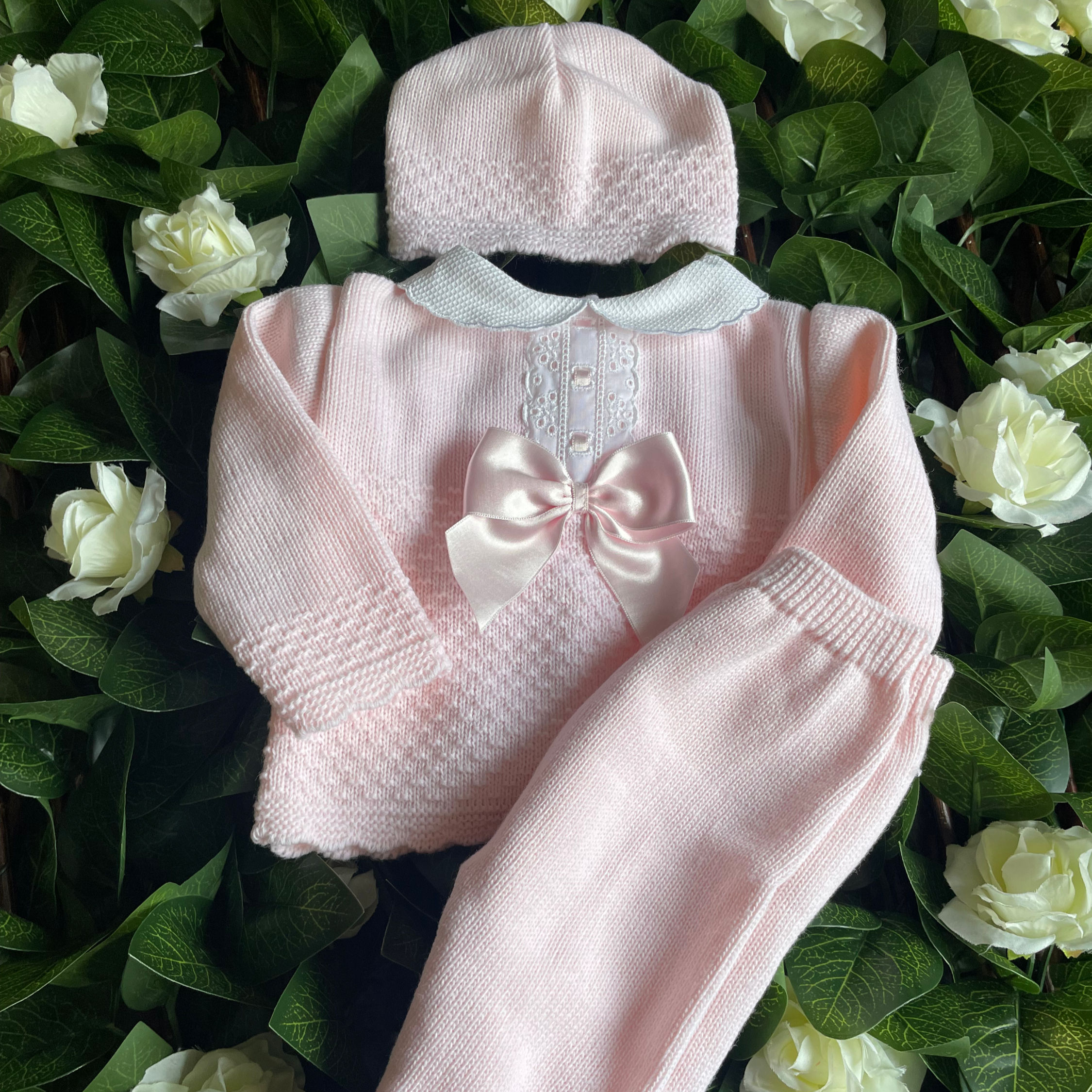 Newborn baby girl three piece knitted outfit, includes; hat, trousers and jumper.