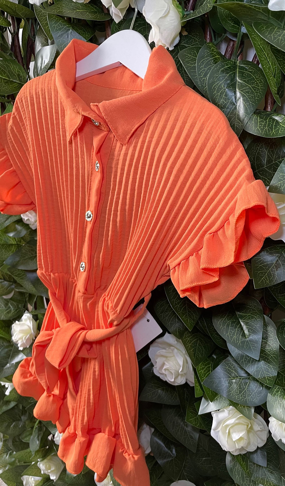 Girls beautiful vibrant pleated orange playsuit, the gold buttons and belted waist add a touch of sophistication.