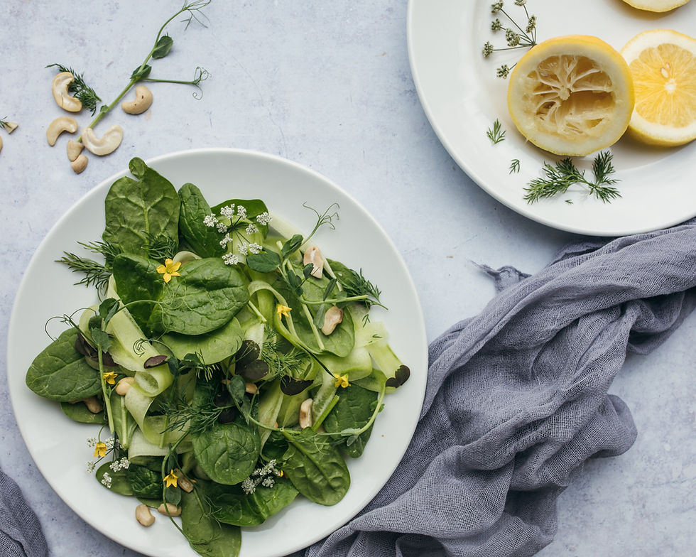 spinach and cucumber salad, on white plate on white background with linen gray cloth