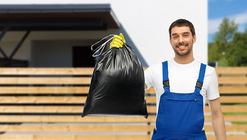A moving professional wearing gloves and holding up a black disposal bag in the air.