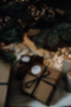 Gesloten mini kerstbox onder een kerstboom met lichtjes