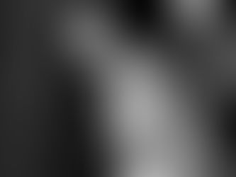 Bride and groom embrace under chandeliers in outdoor setting. Bride in white dress smiles as groom kisses her cheek, glowing in sunset light.