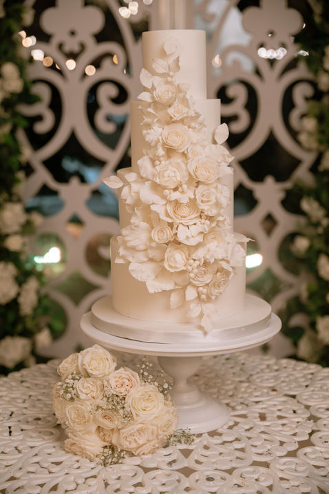 All white fondant wedding cake with white sugar flowers at House of the Orange Blossom in Weslaco, Texas.