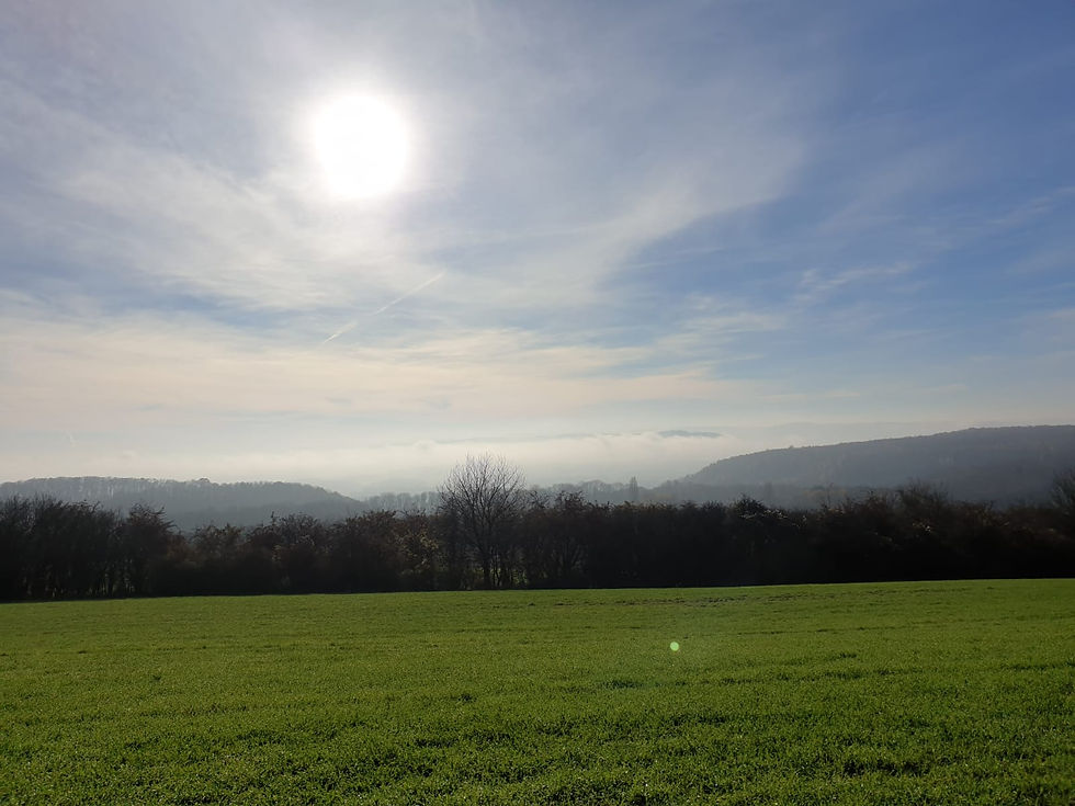 Sonnenlicht bricht durch die Wolken über den saarländischen und lothringischen Feldern an der Beruser Tafeltour.