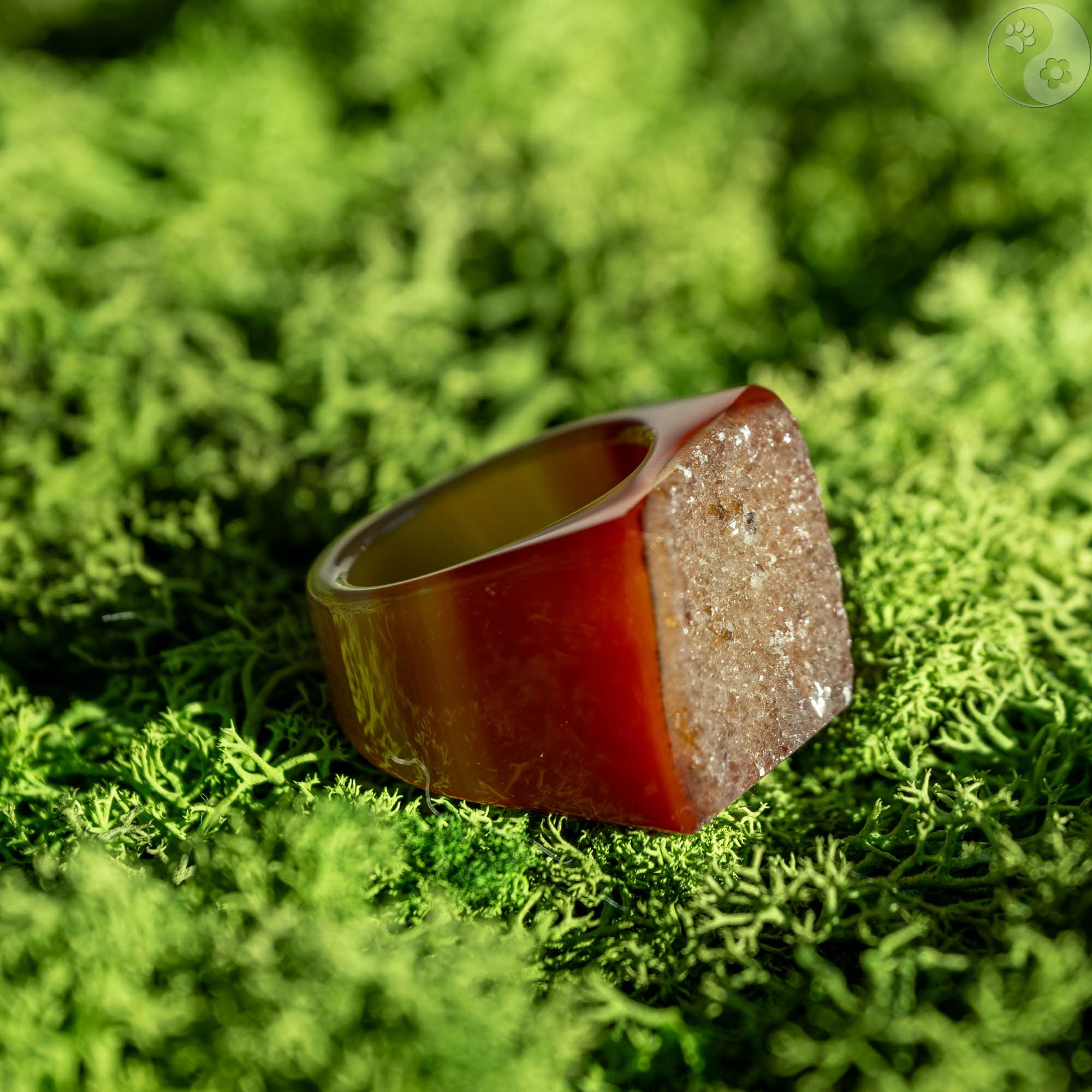 orange brauner Stein-Ring mit weißem Top auf Moosbett, Heilstein-Schmuck, alternative Methoden