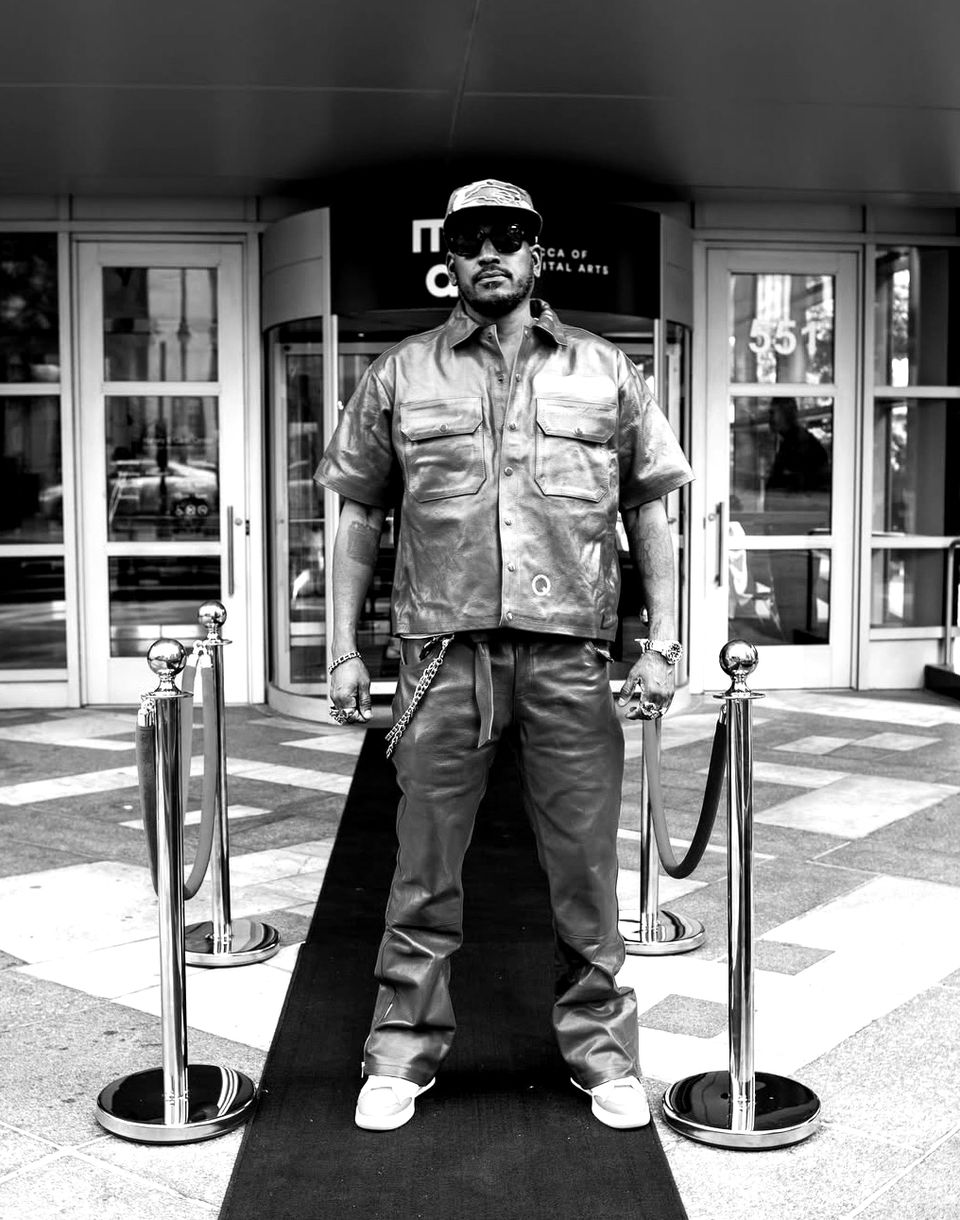 Man stands on a red carpet in front of a building, IT'S CLUB.