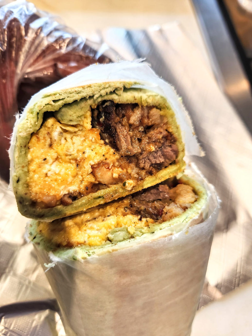 Laud Breakfast Wrap filled with shawarma meat, eggs, and cheese in a tortilla.