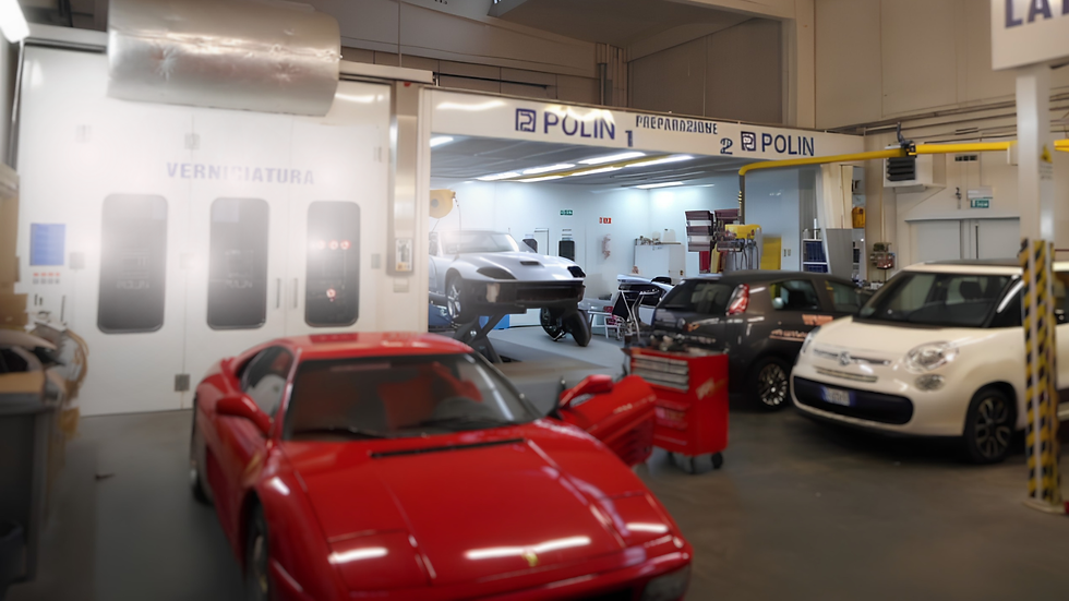 Officina auto con Ferrari rossa e cabina verniciatura