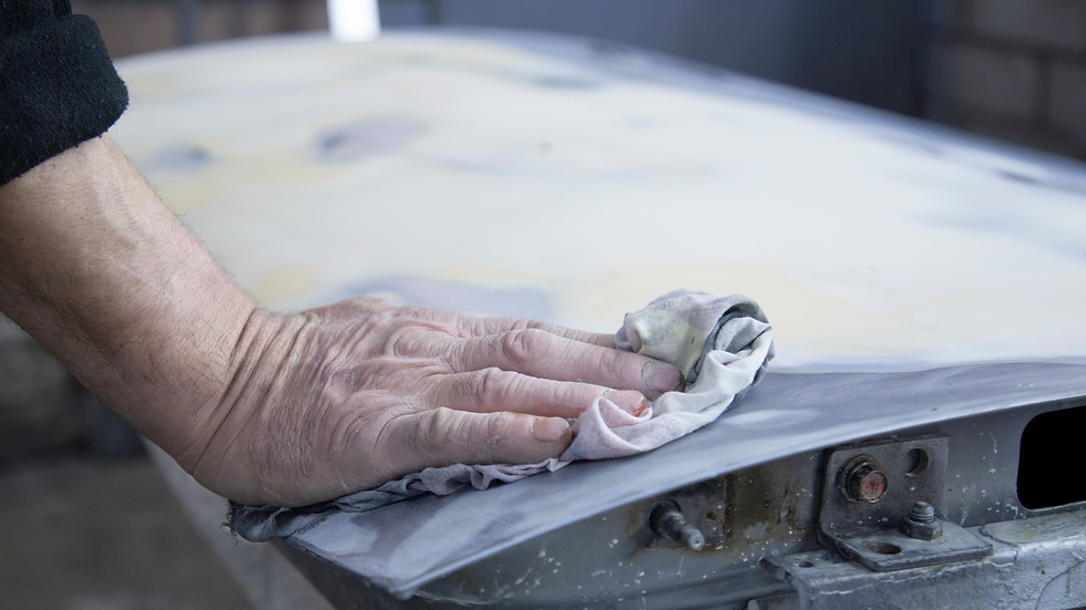 Mano che prepara la carrozzeria auto per la verniciatura