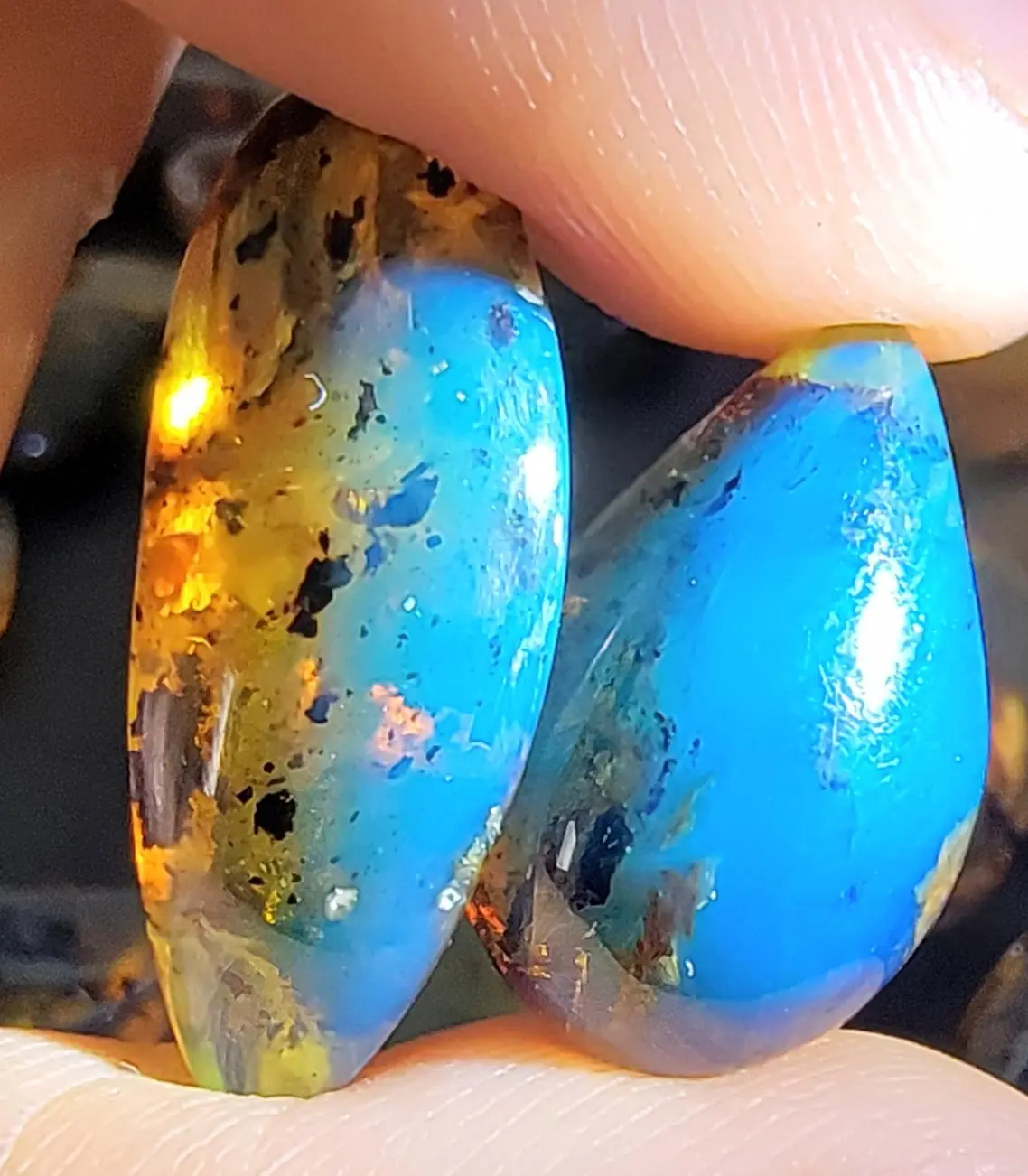 Two pieces of Blue Dominican Amber held in a hand