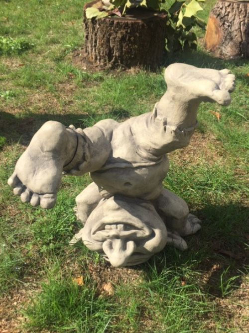 Troll lustig – Steingussfigur für den Garten im Kopfstand auf einer Wiese