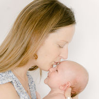 mum kissing baby by Wimbledon London Newborn Photographer Desiree A North. Simple and Natural.