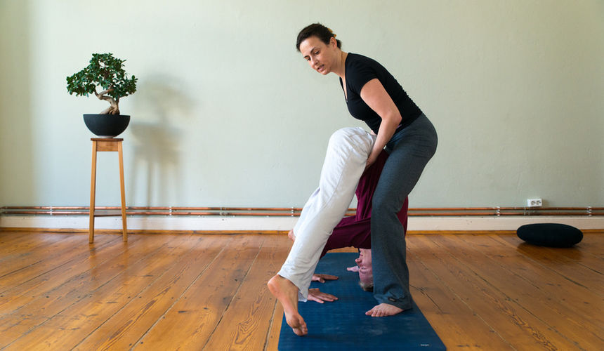 Yogalehrerin gibt Hilfestellung bei Yoga