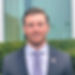 Smiling man in suit with American flag pin