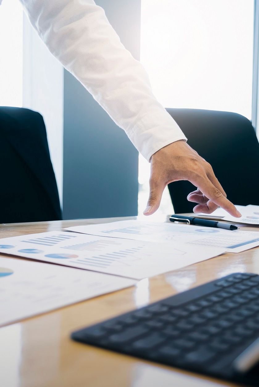 Hand pointing at documents on a table